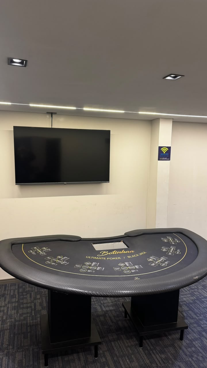 Mesa de jogo com televisão na parede no Home Game