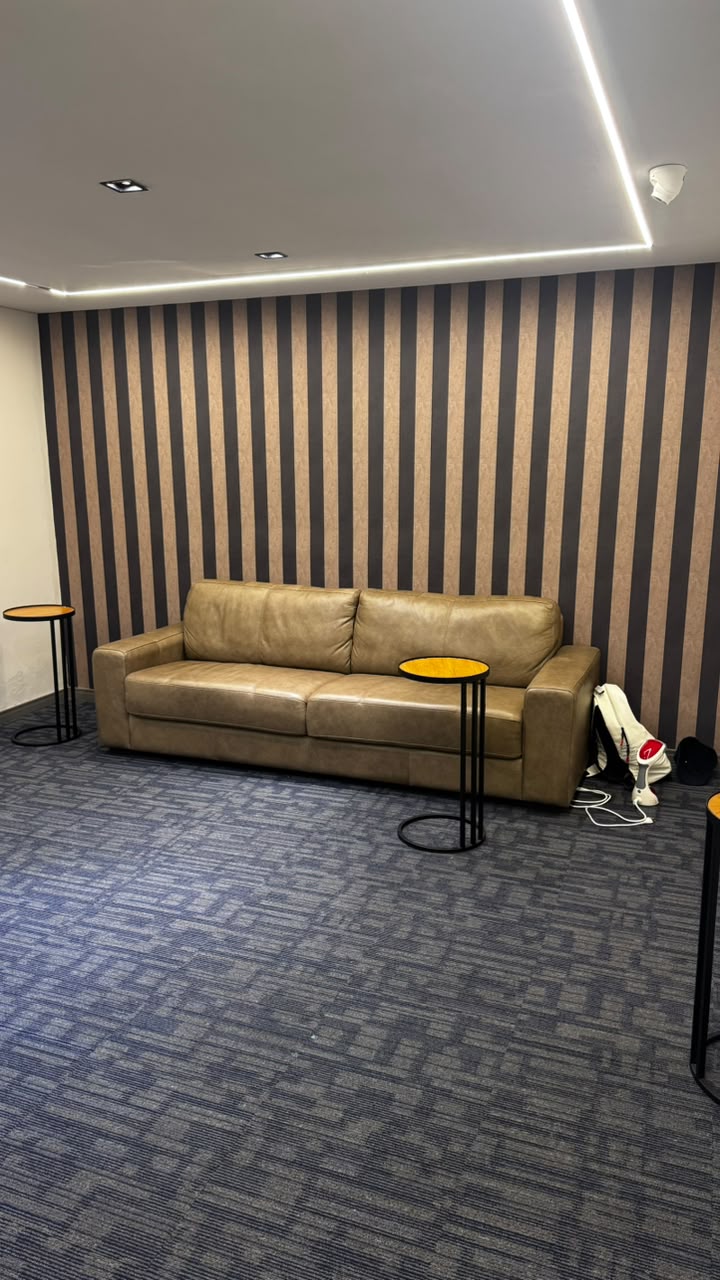 Sofá de couro em área de descanso do Home Game