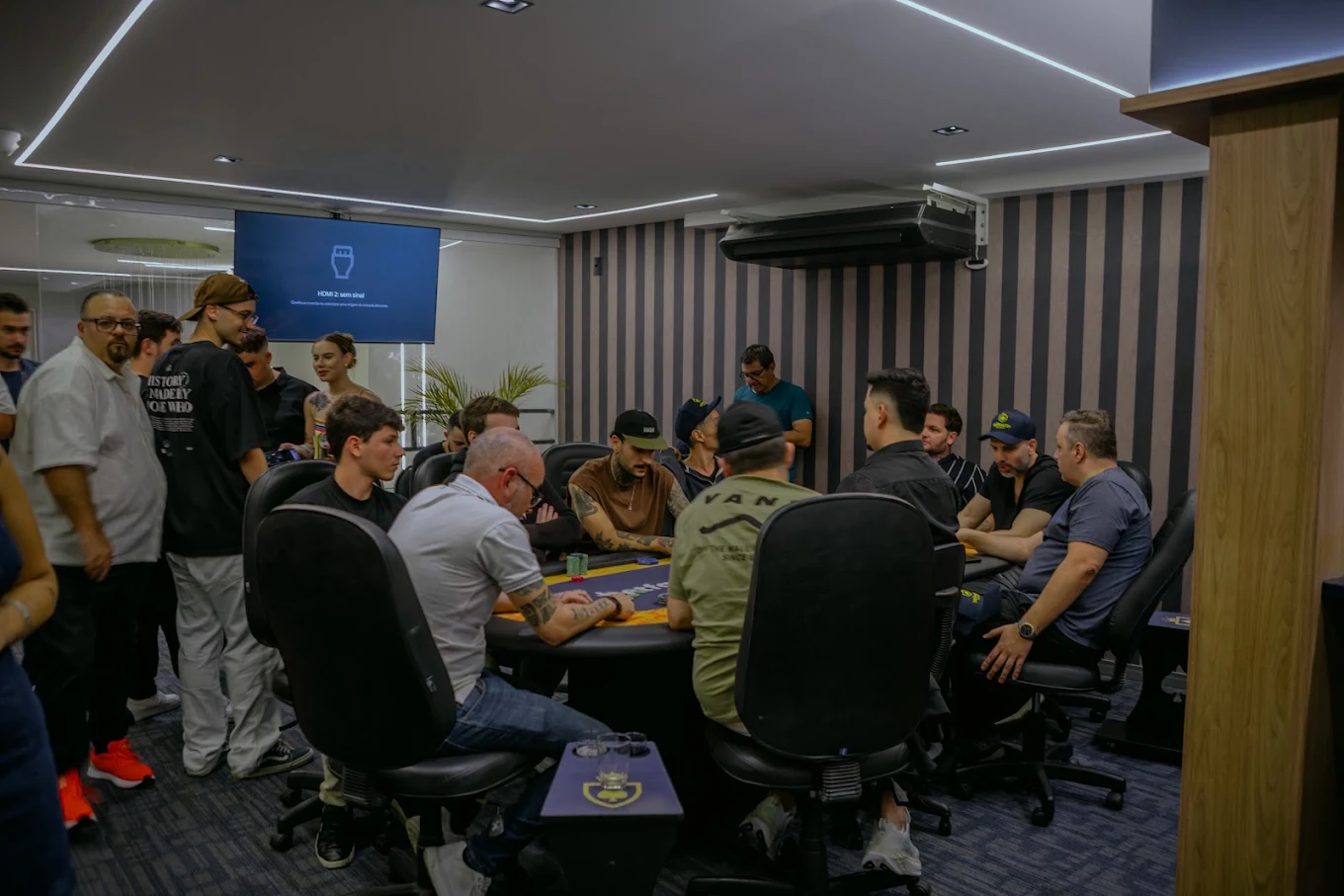 Mesa de poker com jogadores no interior real do Mônaco Poker Bar